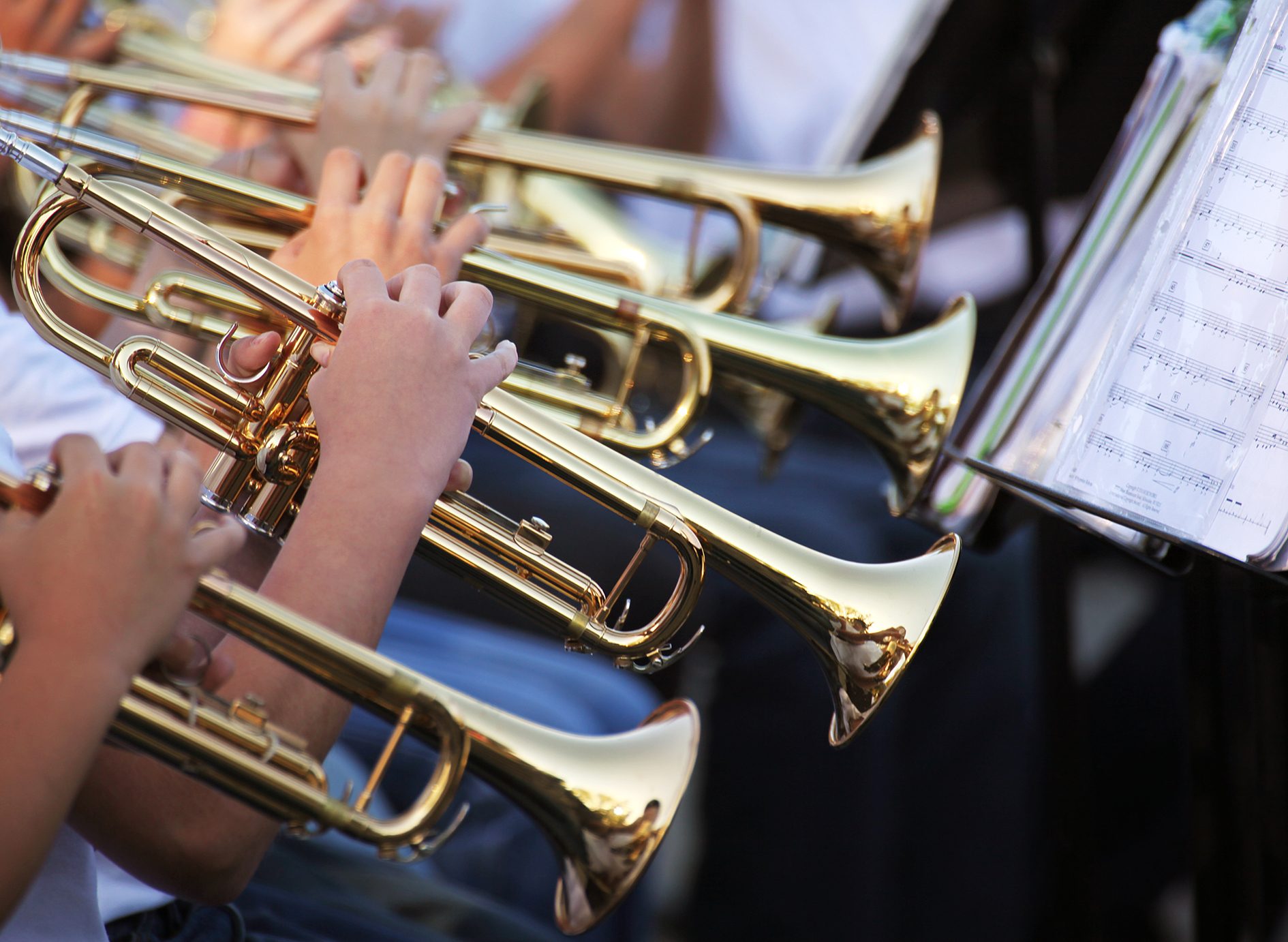 Musicians playing trumpets and sheet music. 