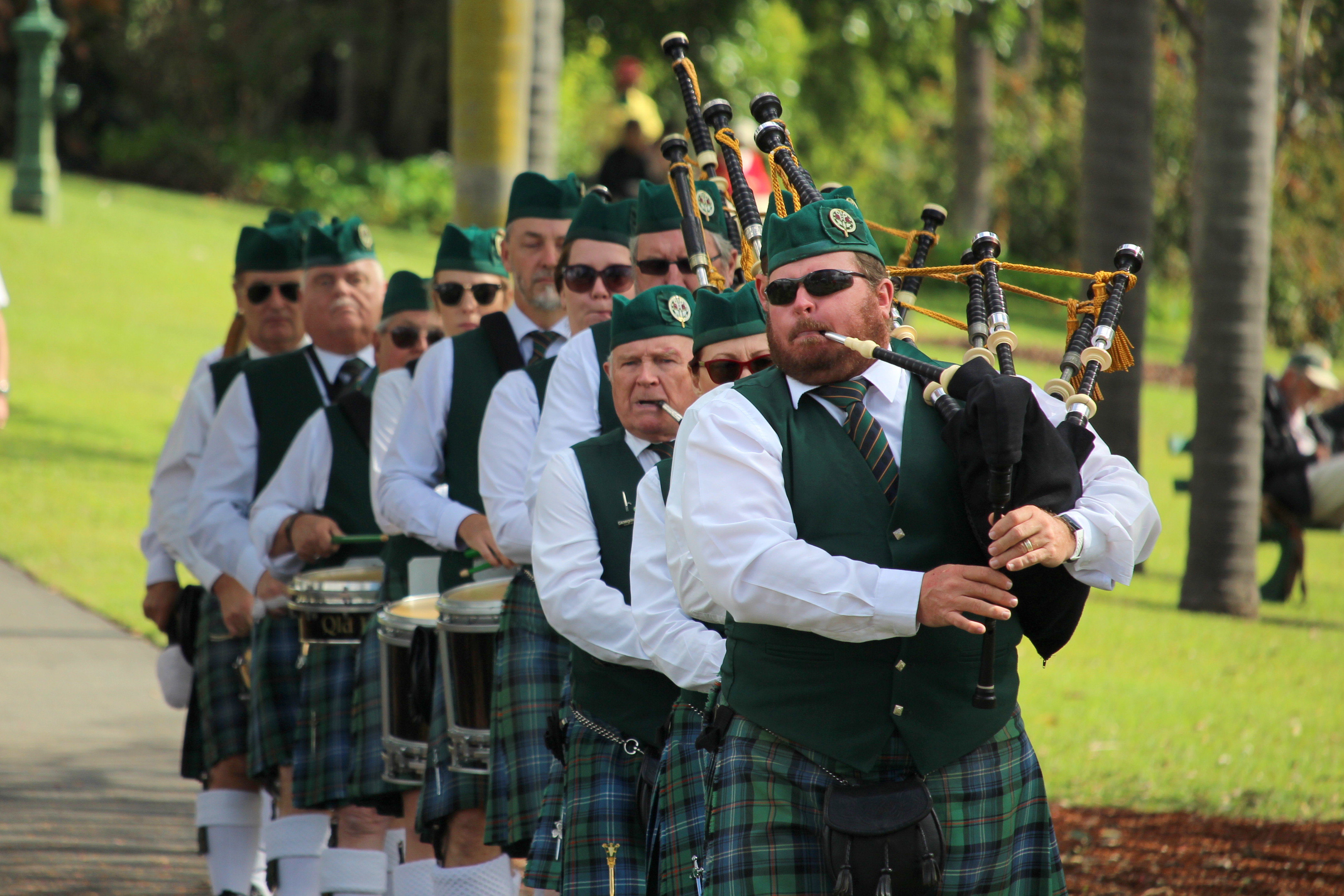 A pipe band dressed in kilts, performing outdoors